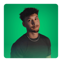 a man in a black shirt is standing in front of a green background